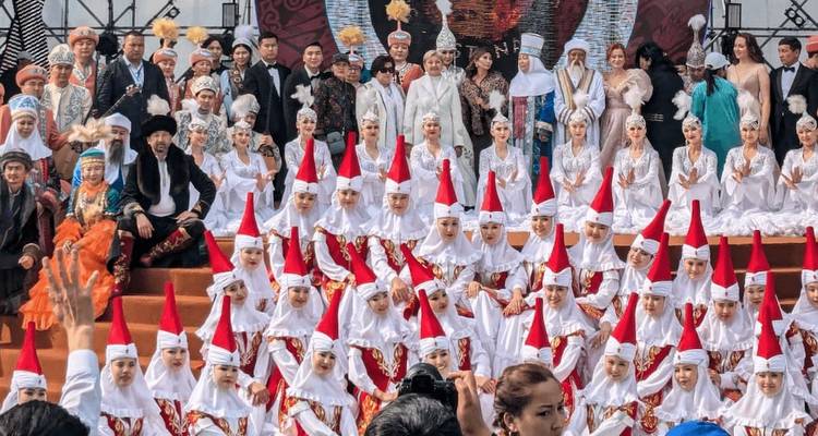 Photo de groupe de personnes en tenue traditionnelle sur scène.
