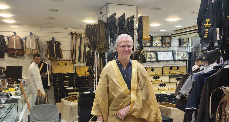 Homme en tenue traditionnelle à l'intérieur d'une boutique de souvenirs.