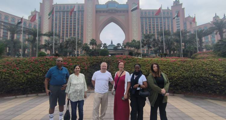 Group of people standing in front of a large hotel resembling Atlantis.