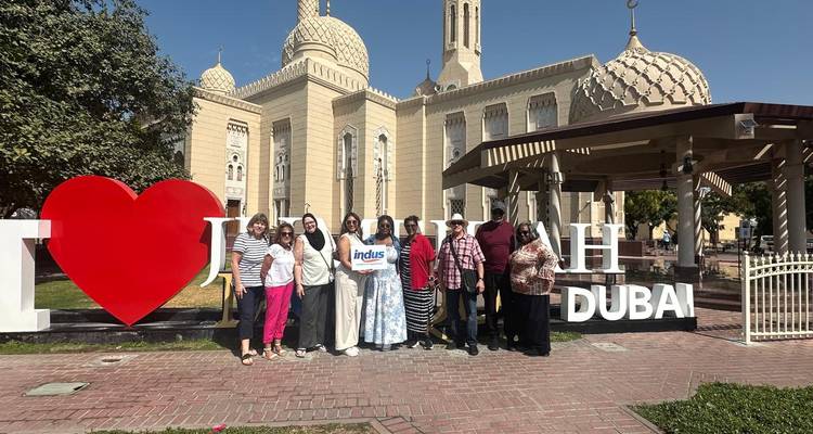 Group of people posing in front of a landmark with I Love Dubai sign.