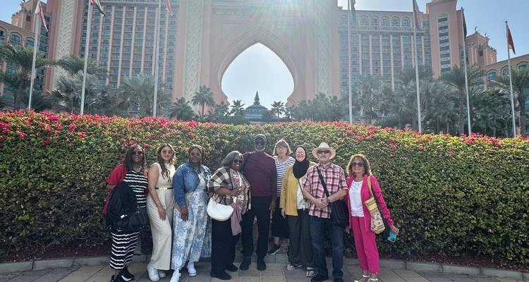 Group of people standing in front of Atlantis-style hotel entrance.