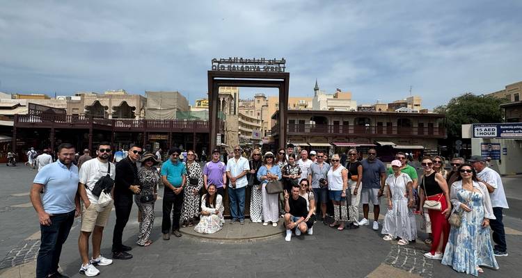 Large group of tourists in a bustling outdoor market area.