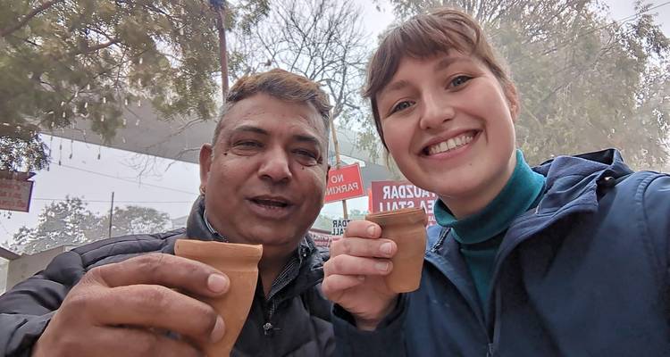 Dos personas sosteniendo tazas tradicionales con una multitud detrás