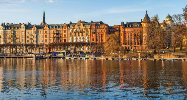 Traditional buildings reflecting in water under clear skies.
