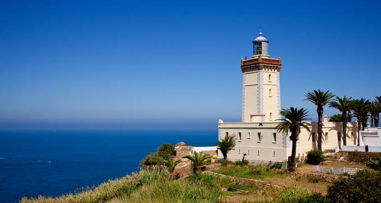 A lighthouse on a cliff with a vast ocean view.