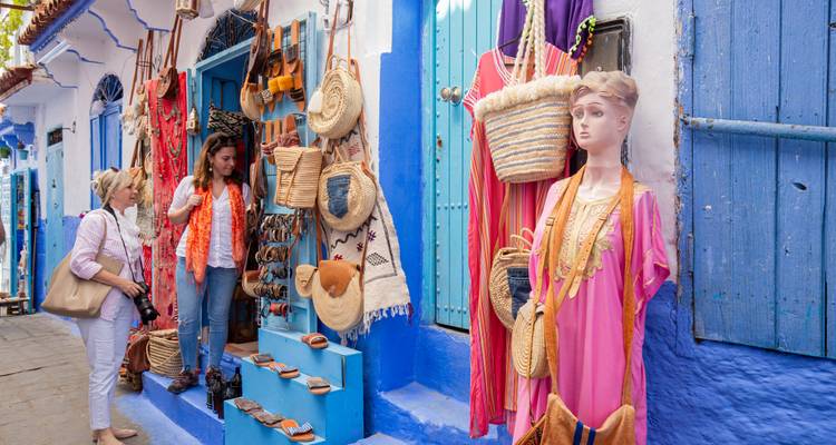 Market scene with traditional crafts and colorful fabrics on display.