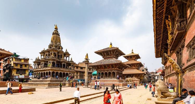 Historic square with temples and people walking around.