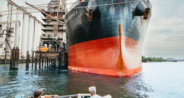 Large ship docked near industrial area.