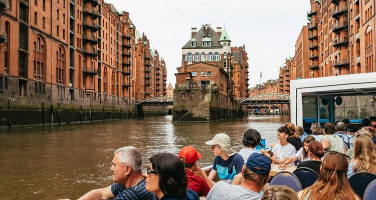 Tourists in a boat touring through a historical canal.