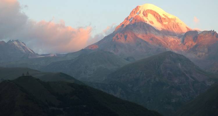 Berglandschaft mit sonnenbeschienem Gipfel, wahrscheinlich der Kasbek.