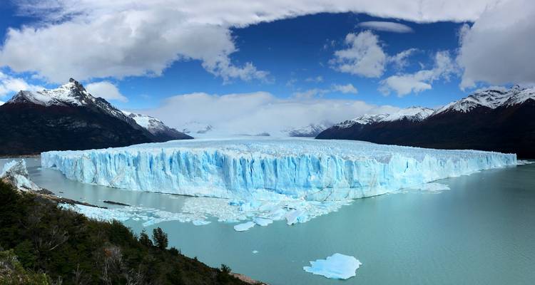 Panoramic view of the Perito Moreno Glacier with mountains and sky.