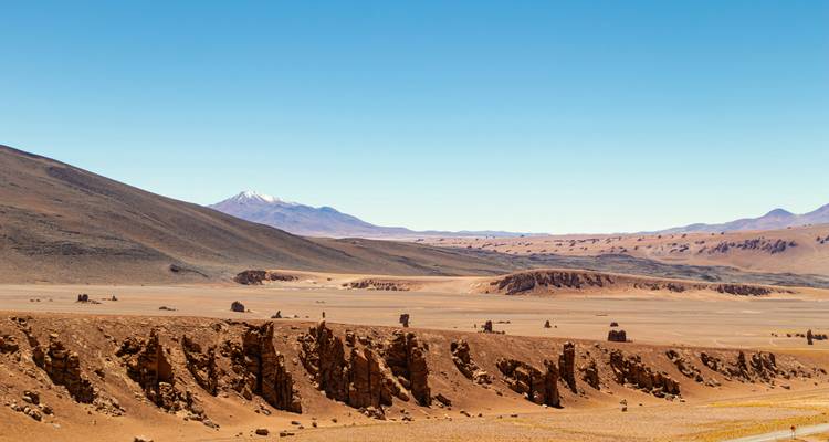 Wide desert landscape with eroded rock formations.
