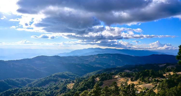 Un magnifique paysage de montagne avec des nuages et un jeu de lumière.