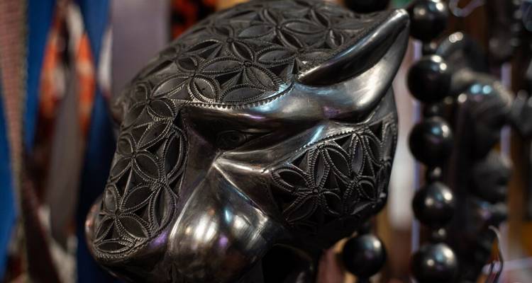 Un gros plan d'un masque de jaguar noir finement sculpté.