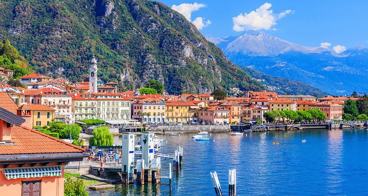 Ville italienne colorée le long d'un lac avec des montagnes.