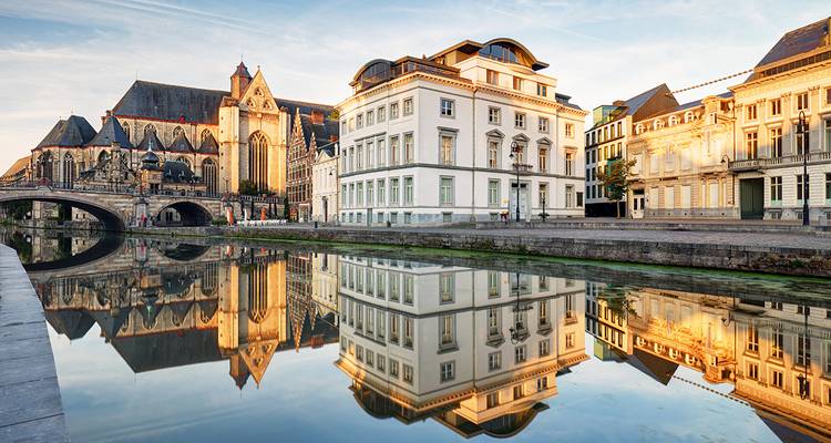 Canal in Ghent with reflection of historic buildings.