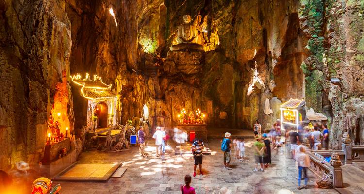Intérieur de temple avec un bel éclairage et plusieurs visiteurs.