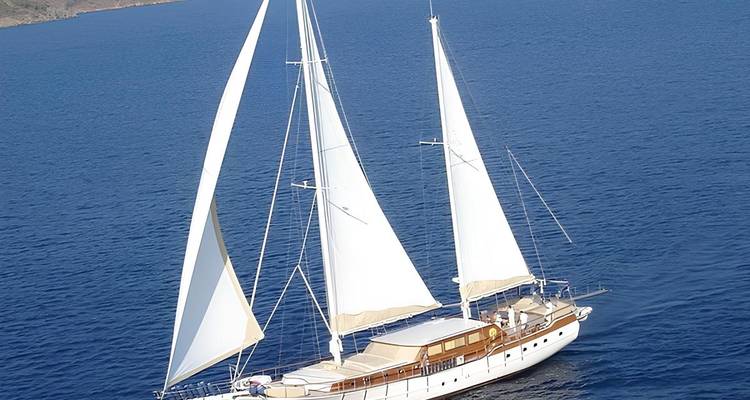 Large white sailing yacht cruising in open water.