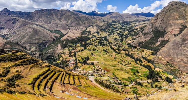 Vista aérea de un valle con campos en terrazas y un pueblo.