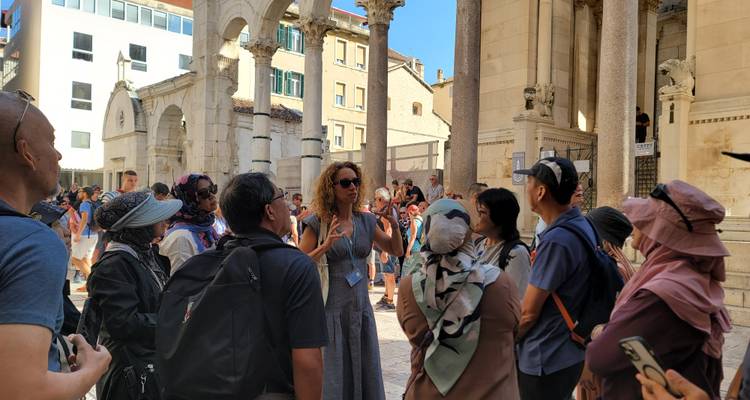 Tour group listening to a guide at a historical site.