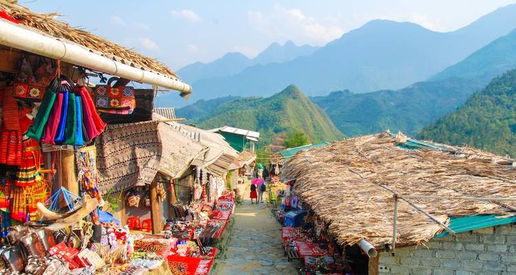 Marché dans une zone montagneuse avec des étals vendant des marchandises.