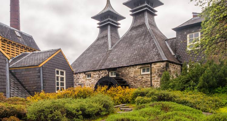Distillery with distinctive roof architecture and garden.
