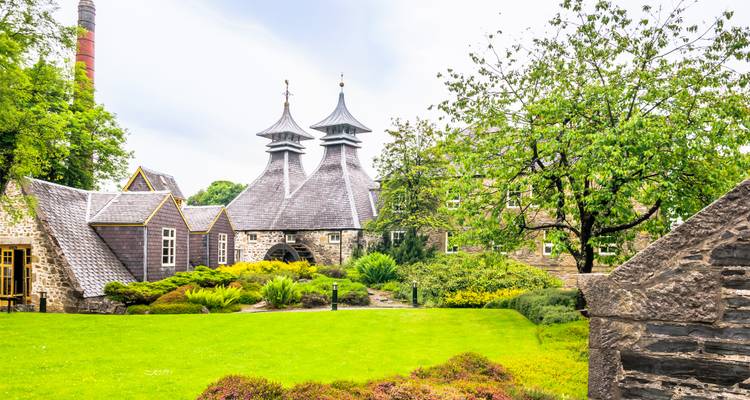 Distillery with distinctive roof and lush green garden.