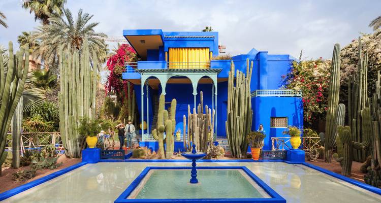 Majorelle Garden with colorful buildings and lush plants.