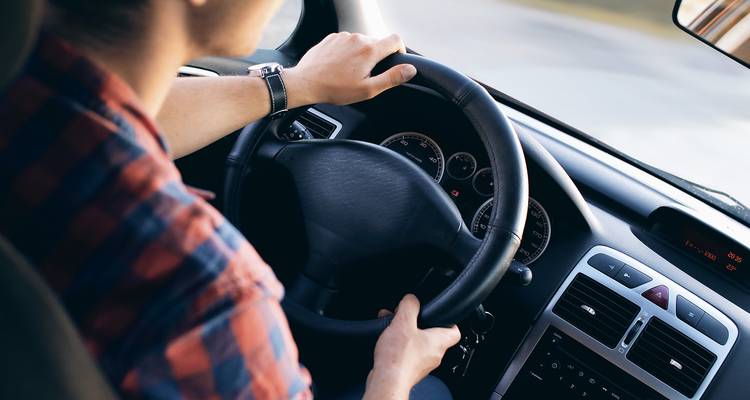 Gros plan d'une personne conduisant une voiture.