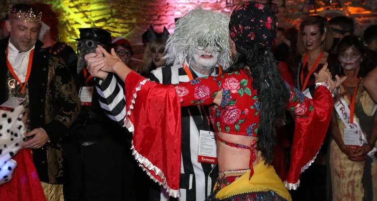 People in costume dancing at a festive event.