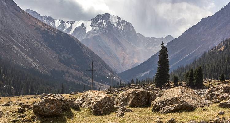 Mountainous landscape with a valley and snow-capped peaks.