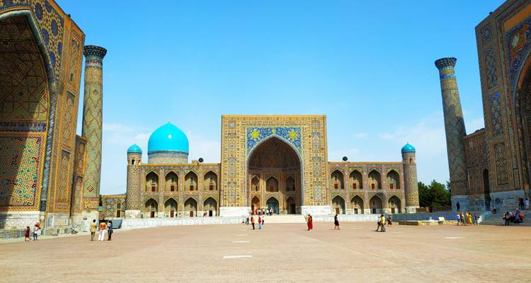 Historical madrasa complex with blue domes and intricate patterns.