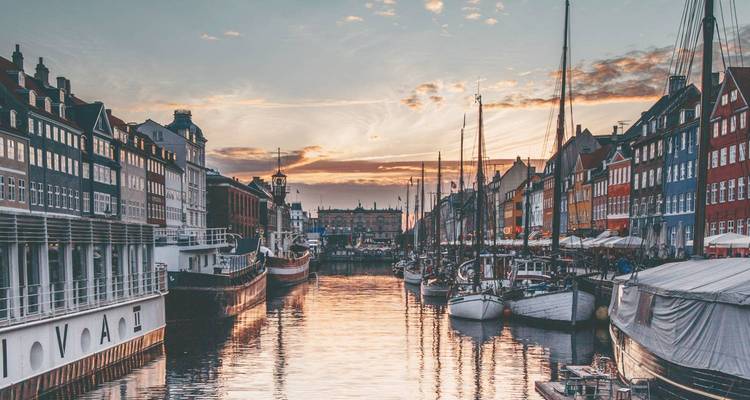 Sunset view of Copenhagen harbor with reflections in the water.