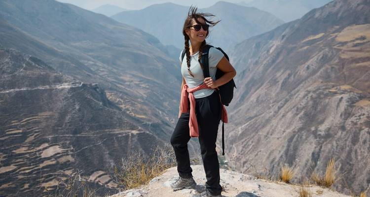 Femme debout au sommet d'une montagne profitant de la vue.