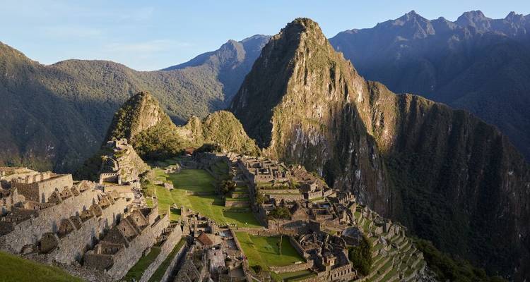 Vue emblématique des ruines du Machu Picchu entourées de montagnes.