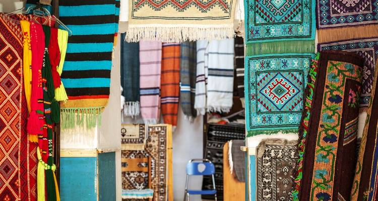 Kleurrijke textiel en tapijten in een marktkraam.