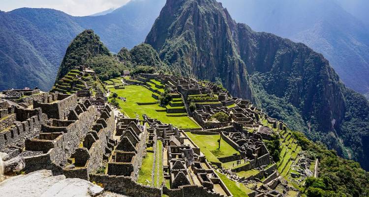 Vue du Machu Picchu avec une végétation luxuriante et des montagnes.
