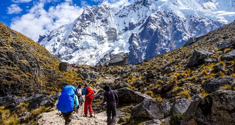 Randonneurs marchant vers la montagne Salkantay dans un paysage rocheux.