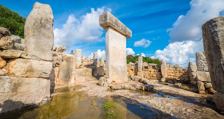 Structure de pierre ancienne sous un ciel bleu avec quelques nuages.
