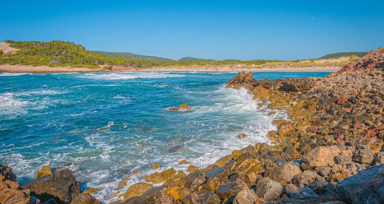 Côte rocheuse avec des vagues qui se brisent contre les rochers.