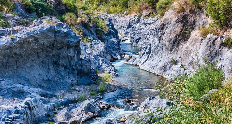 A rocky river gorge with clear water flowing through.