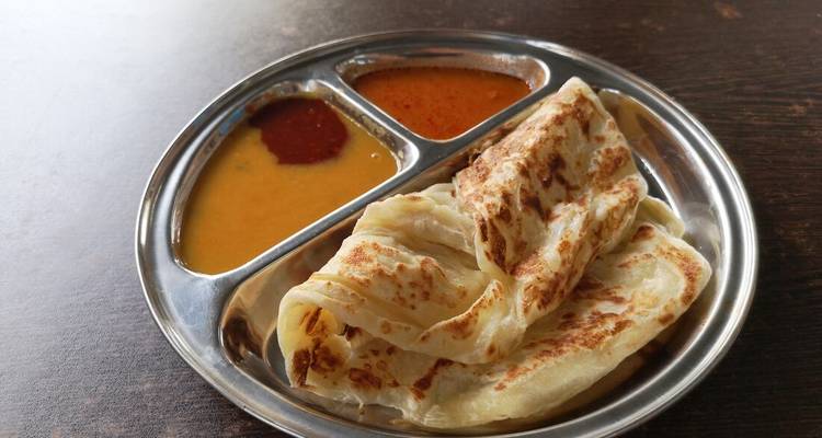 A dish with flatbread and various dipping sauces.