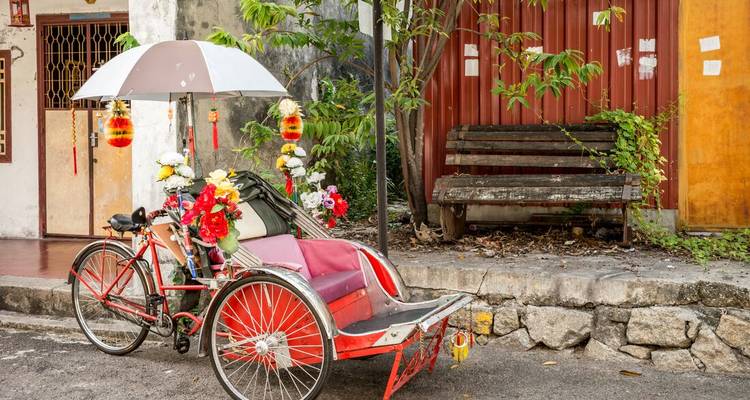 A decorated rickshaw parked on a street.