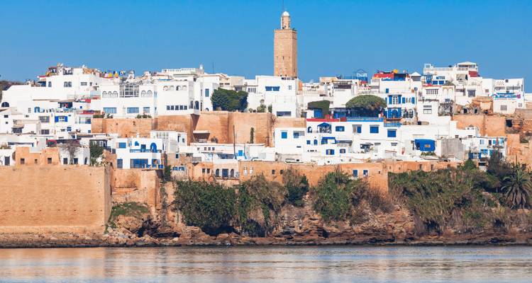 Cityscape with historic walls and buildings near the sea.