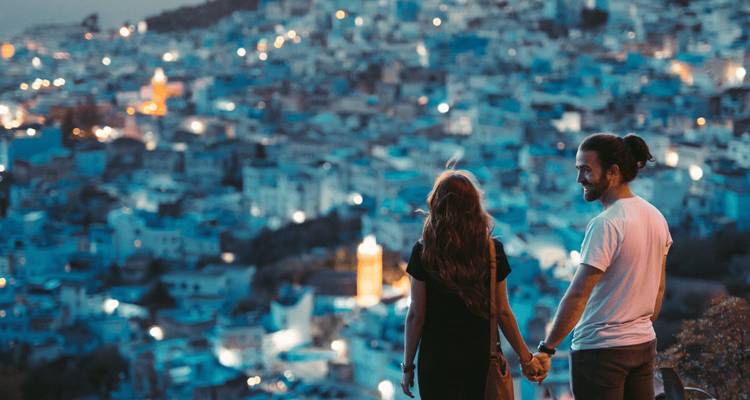 A couple looking at Chefchaouen, the blue city, during the evening.