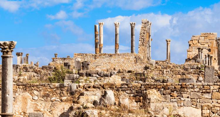 Ancient ruins with pillars under a blue sky.