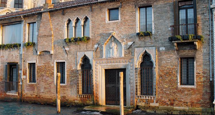 An ornate brick building in Venice with Gothic architecture.