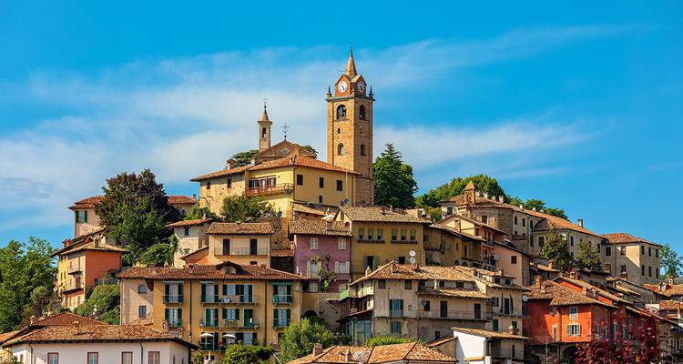 Vue panoramique d'un village perché avec des bâtiments colorés.