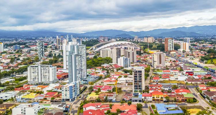 Vue aérienne de San José avec architecture moderne et montagnes.