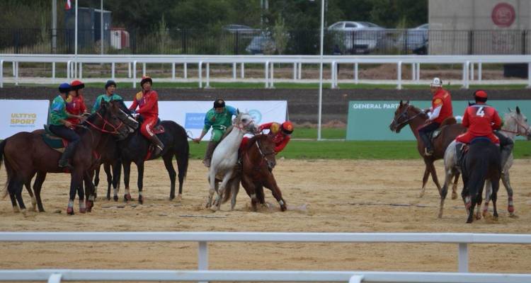 Jinetes jugando un deporte ecuestre tradicional en una arena.